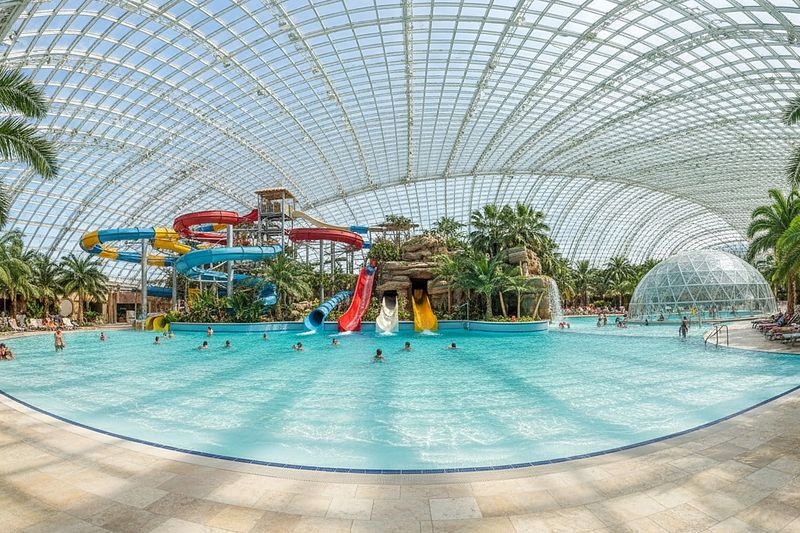 The Galaxy zone at Therme: slides, wave pool and palms under the glass dome